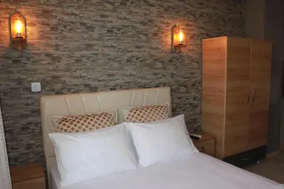 a bedroom with a bed with two pillows and a brick wall at yelken apart hotel in Tekirdag