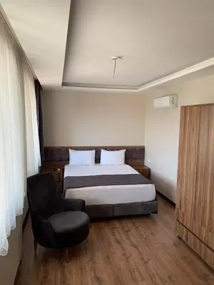 a bedroom with a bed and a chair at Royal Residence Bursa in Bursa