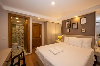 a bedroom with a bed and a desk and a bathroom at TAKSİM SUİTE in Istanbul