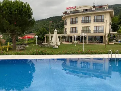 a hotel with a swimming pool in front of a building at Motali Life Hotel in Masukiye