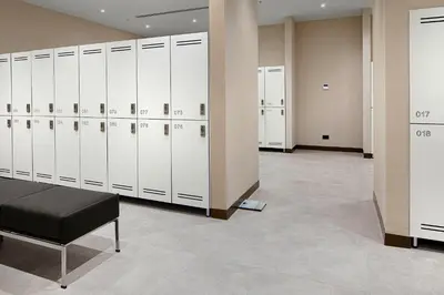 a locker room with white lockers and a black stool at Wanda Vista Istanbul in Istanbul