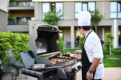 a chef standing next to a grill with food at Antwell Suites in Istanbul