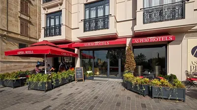 a restaurant with red umbrellas in front of a building at Aspera Hotel Golden Horn in Istanbul