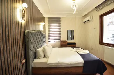 a bedroom with a bed with a headboard and a window at Istanbul Galata Port Modern Suite & Apartments Taksim in Istanbul