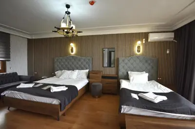 a hotel room with two beds and a couch at Istanbul Galata Port Modern Suite & Apartments Taksim in Istanbul