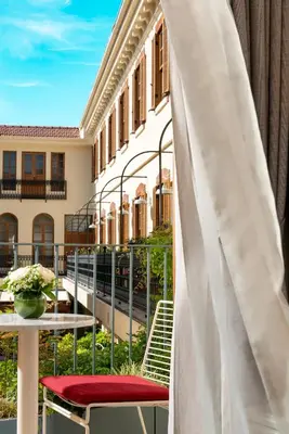 a balcony with a table and a white umbrella at Ecole St. Pierre Hotel in Istanbul
