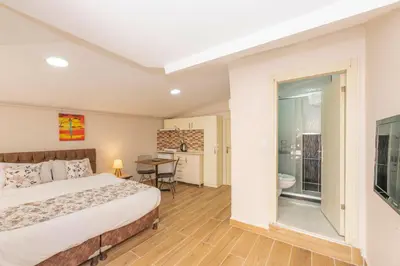 a bedroom with a bed and a table and a bathroom at Marida Residence - Istanbul Taksim in Istanbul