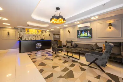 a living room with a couch and a table and chairs at Comfort Suites Hotel in Istanbul