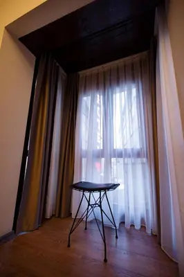 a table in front of a window with curtains at Grand Balyan Hotel & Restaurant in Istanbul