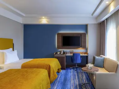 a hotel room with two beds and a tv at Mövenpick Hotel Istanbul Asia Airport in Istanbul
