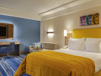 a hotel room with a large bed and a desk at Mövenpick Hotel Istanbul Asia Airport in Istanbul