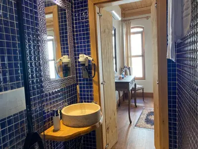 a bathroom with a sink and a blue tiled wall at Sofia Konaklama in Istanbul