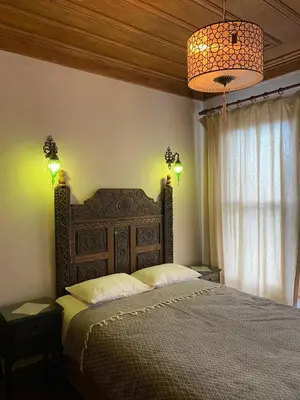 a bedroom with a bed and a chandelier at Sofia Konaklama in Istanbul