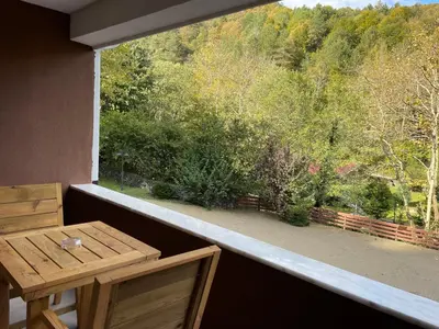a balcony with a wooden table and a view of trees at Feel & Live Hotel Villas Restaurant Sapanca in Sakarya