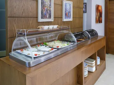 a buffet in a restaurant with food in a display case at Merlin Hotel İstanbul in Istanbul