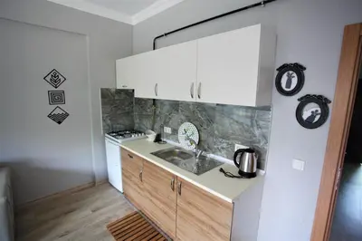 a kitchen with white cabinets and a sink at Bahçeli Concept Sapanca in Sapanca