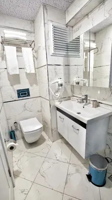 a white bathroom with a sink and a toilet at Cape Palace Hotel in Istanbul