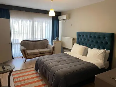 a bedroom with a large bed and a chair at EVİM APART HOTEL in Termal