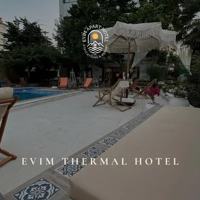a hotel with chairs and an umbrella and a pool at EVİM APART HOTEL in Termal