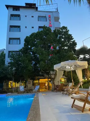 a swimming pool with chairs and umbrellas next to a building at EVİM APART HOTEL in Termal