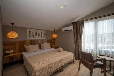a bedroom with a bed and a table and a window at Villa Siesta Hotel Istanbul Airport in Karaburun