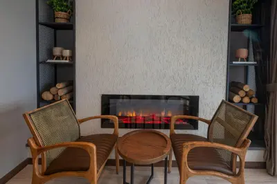 a living room with a table and chairs and a fireplace at Villa Siesta Hotel Istanbul Airport in Karaburun
