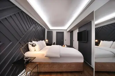 a bedroom with a large white bed and a television at Xenia Hotel Istanbul in Istanbul