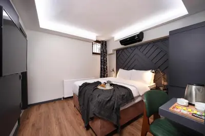 a bedroom with a large bed and a table at Xenia Hotel Istanbul in Istanbul