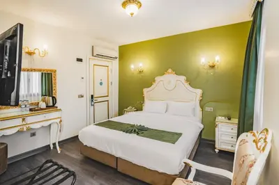 a bedroom with a white bed and a television at Hotel Fresia Istanbul in Istanbul