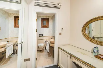 a bathroom with a sink and a toilet and a mirror at Hotel Fresia Istanbul in Istanbul