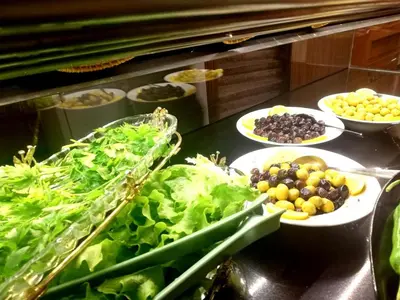 a buffet line with plates of lettuce and olives at Gafa Garden Hostel & Apartments - Great Location in Istanbul