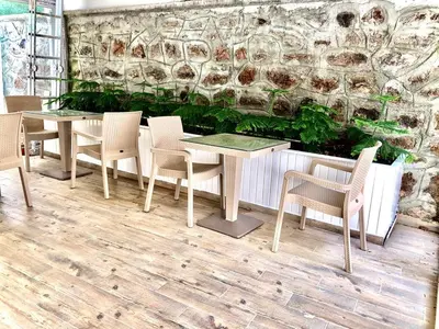 a restaurant with tables and chairs in front of a wall at White Island Boutique Otel in Adalar