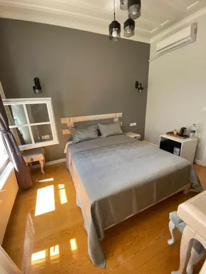 a bedroom with a large bed and a wooden floor at White Island Boutique Otel in Adalar