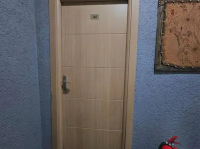 a wooden door in a room with a blue wall at Grey House Apartments & Suites Istanbul in Istanbul