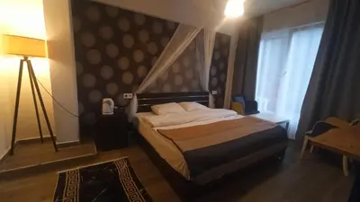 a bedroom with a bed and a lamp and a window at Gölyaka Hotel in Bursa
