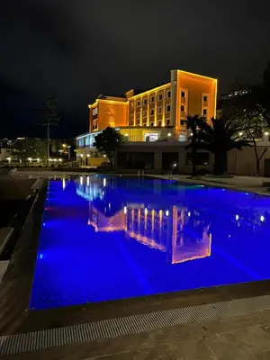 a large swimming pool with blue lighting in front of a building at The Sign Degirmen Hotel&Spa Wellness in Istanbul