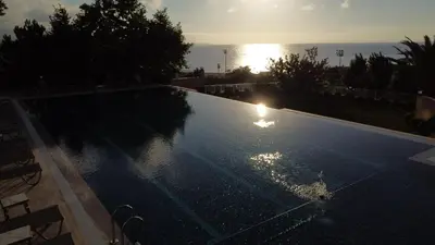 a swimming pool with the sun setting over the ocean at The Sign Degirmen Hotel&Spa Wellness in Istanbul