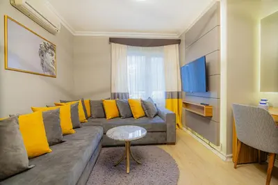a living room with a gray couch and yellow pillows at La Palace Exclusive Design in Istanbul