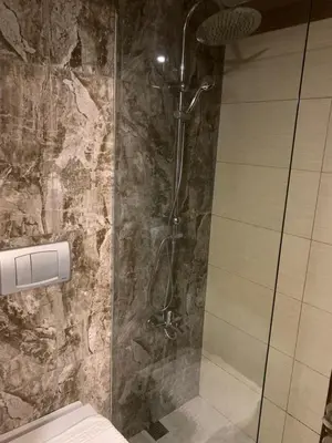 a shower in a bathroom with a stone wall at La Palace Exclusive Design in Istanbul
