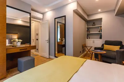 a bedroom with a bed and a desk and a chair at SALA SUITES in Istanbul