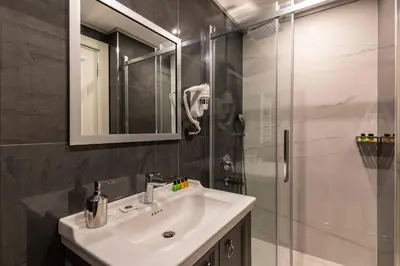 a bathroom with a sink and a glass shower at SALA SUITES in Istanbul