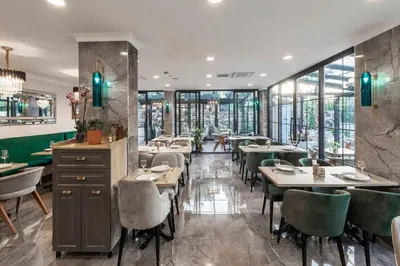 a restaurant with tables and chairs and windows at LAGUN CASTLE HOTEL&SPA in Yalova