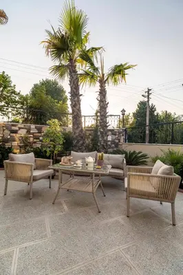 a patio with a table and chairs and palm trees at LAGUN CASTLE HOTEL&SPA in Yalova