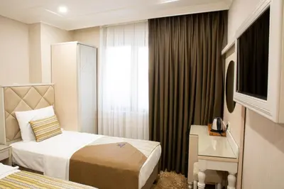 a hotel room with two beds and a television at Alpinn Hotel DUE in Istanbul