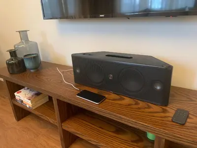 a black speaker sitting on a wooden table at Superior refurbished flat in the heart of Istanbul in Istanbul