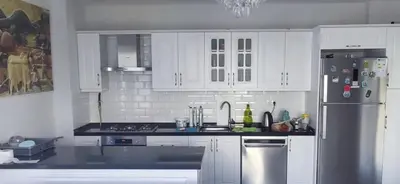 a kitchen with white cabinets and a stainless steel refrigerator at Sapanca villa in Sapanca