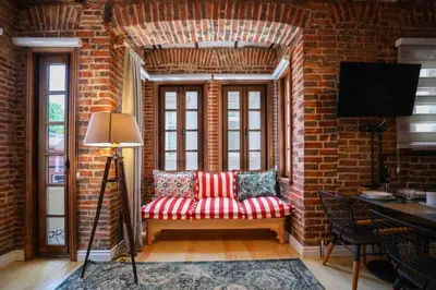 a living room with a red couch and a brick wall at Galadoo Suites 2nd Floor in Istanbul