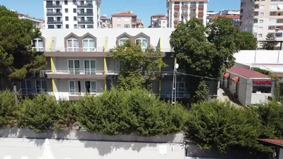 an apartment building with trees in front of buildings at TALEN OTEL in Istanbul