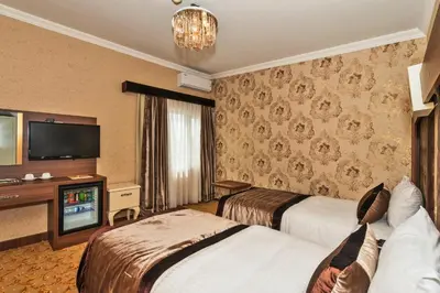a hotel room with two beds and a television at Montagna Hera Hotel Taksim in Istanbul