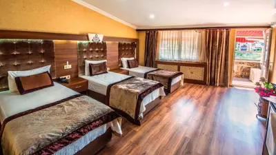 a hotel room with three beds and a window at Montagna Hera Hotel Taksim in Istanbul